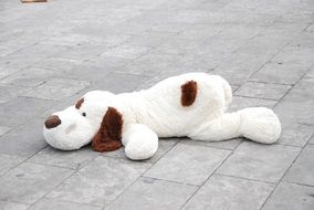 toy dog lays down on pavement