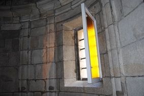 open stained glass window of aged church, spain