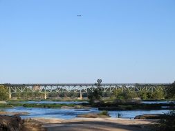 bridge above river against blue sky