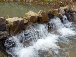 Waterfall among the stones on the river