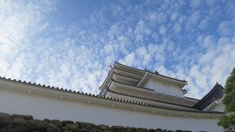 white castle in japan under a blue sky with white clouds