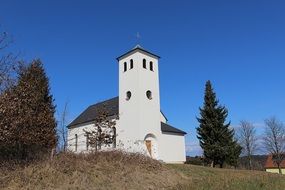 remote view of a catholic church on a hill in the countryside