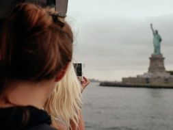 girl looks at the statue of liberty