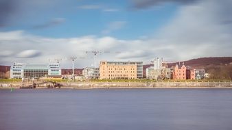 cranes at buildings under construction on bank of rhine river, architecture panorama, germany, bonn