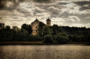 monastery by the river near green trees