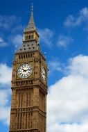 Clock tower against the sky with white clouds