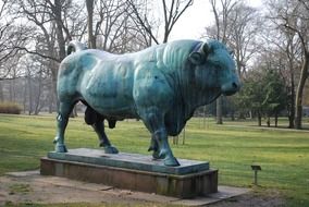 bull like bronze sculpture in the park among the plants