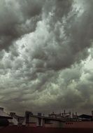 stormy weather, dramatic grey clouds in sky above roofs