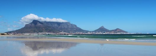 Table Mountain is reflected in the ocean in Cape Town