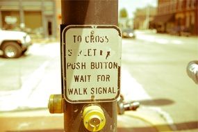 pole with signal button on crosswalk in city