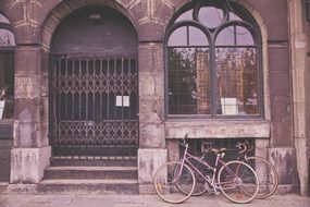 bicycles are parked under the window of a historic building