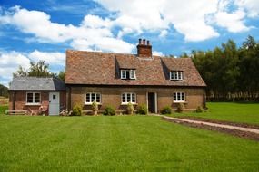 cottage stands on a green meadow