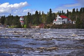 House near the river near the coniferous forest, quebec