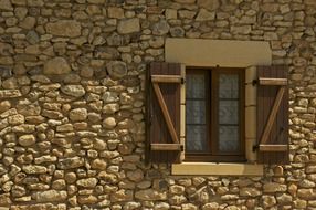 Window on a stone house wall under the light