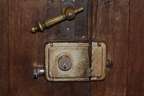 vintage bronze door handle and old lock on wooden door