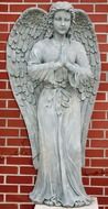 statue of an angel near a brick wall