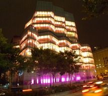 illuminated modern building on street at night, usa, new york city