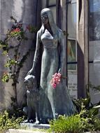 statue of a woman with flowers in a cemetery