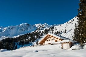 house in the snowy alps on a sunny day