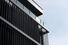 corner of the glass building with stripes on the background of sky