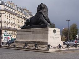 huge lion statue on a city street in paris