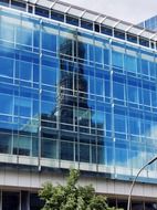 church mirroring on contemporary blue glass facade, germany, hamburg