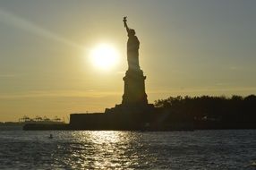 Statue of liberty in the background of the sun