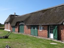 old red brick farmhouse with green doors, denmark