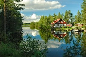 reflection of a wooden cottage on the surface of a lake in Sweden