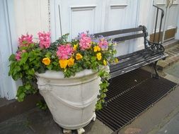 flowerpot near wooden bench at sidewalk