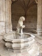 A statue of a lion in a fountain in the monastery of Lisbon