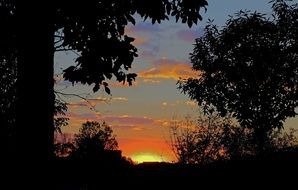 orange clouds over the outskirts of the city in the evening