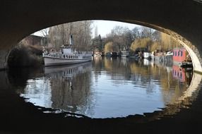 boat is moored at the promenade in Berlin view from under the bridge