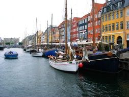 boats moored on a canal along colorful buildings in Copenhagen