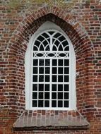 white arched window of a historic brick house