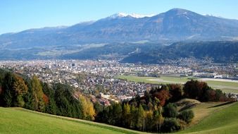 a panorama of green hills and the city of Innsbruck aerial view