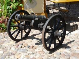 aged cannon on cobblestone pavement