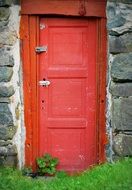 old red front door of a stone building