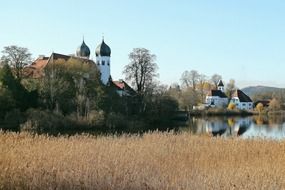 monastery behind green trees in upper bavaria