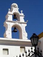 bells on a white tower in a cemetery in Buenos Aires