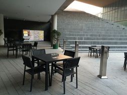 wooden tables and chairs on the street near the cafe