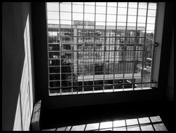 Black and white photo of the grated window in room of bauhaus building, germany, dessau