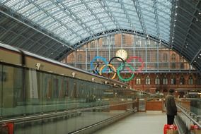 a train station in London against the backdrop of the Olympic Games symbol