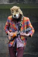 masked street musician playing guitare