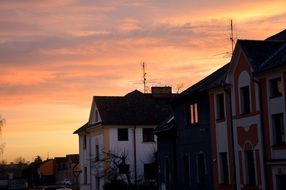 orange sunset sky over houses at dusk