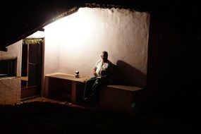 senior man sitting in house at night