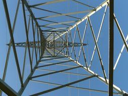 metal tower with electric wires under blue sky