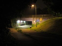 Urban street with graffiti on the wall at night time