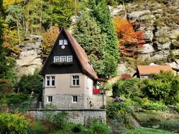 landscape of three girl house at rock in autumn