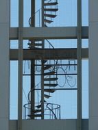 spiral staircase behind window of modern building